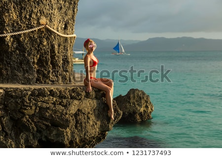 Сток-фото: A Girl Sits On A Rock On The Beach Of Boracay