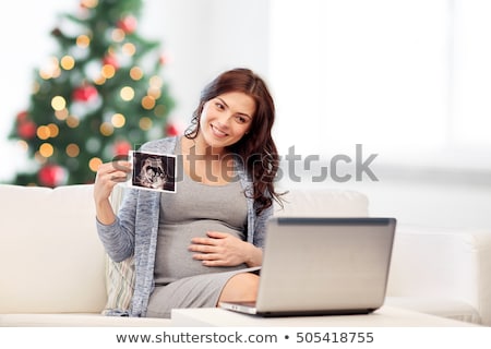 Foto stock: Pregnant Woman With Ultrasound Images At Christmas