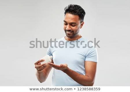 ストックフォト: Happy Indian Man Applying Lotion To His Hand