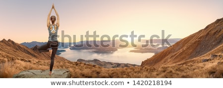 Stock fotó: Happy Athletic Woman Practicing Yoga On The Rocks By The Sea