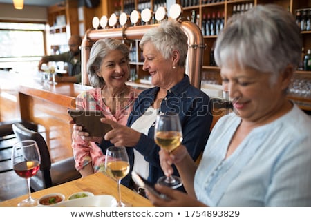 Foto stock: Happy Senior Friends Having Glass Of Wine In Bar