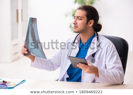 Zdjęcia stock: Young Doctor Looking At X Ray Image In Mhealth Concept