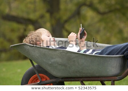 ストックフォト: マート携帯電話を使用して手押し車を置く少年