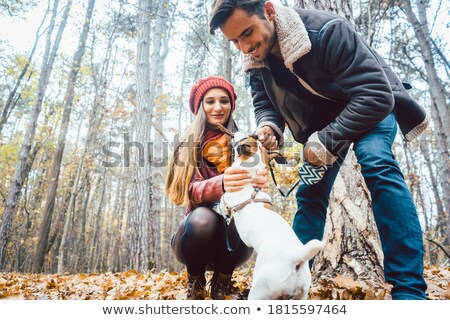 Foto d'archivio: Woman And Man Walking Their Dog Throwing A Stick