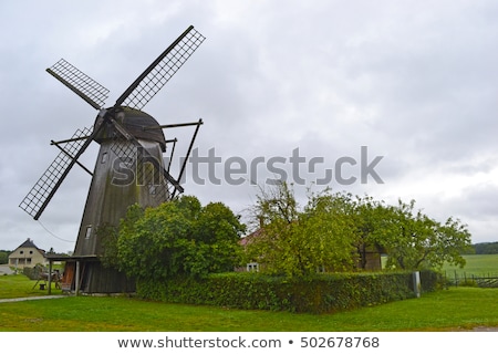 Stok fotoğraf: Traditional Wooden Windmill In A Lush Garden