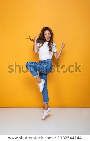 Foto stock: Full Length Portrait Of A Cheerful Girl With Long Dark Hair