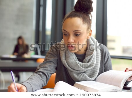 Foto stock: Close Up Of African Student Girl Reading Textbook