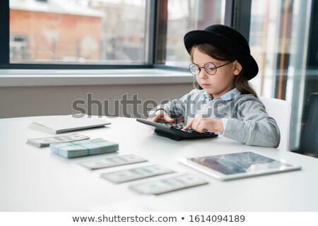 Foto stock: Little Accountant Using Calculator While Counting Salary Or Money