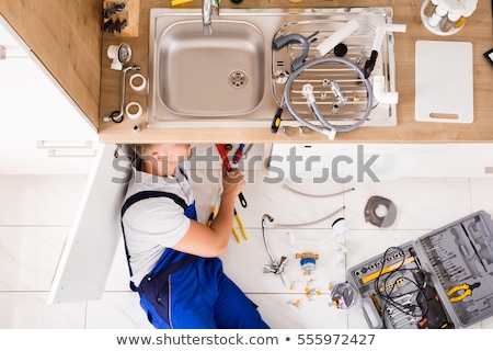 Stock fotó: Plumber In Overall Fixing Sink Pipe