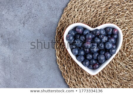 Foto stock: Blueberry In Bowl On Straw Table Mat On Blue Background