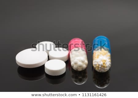 Foto stock: Yellow And Red Medical Capsules On A Mirror Surface