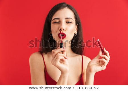 Zdjęcia stock: Woman Posing Isolated Holding Lip Gloss Doing Makeup