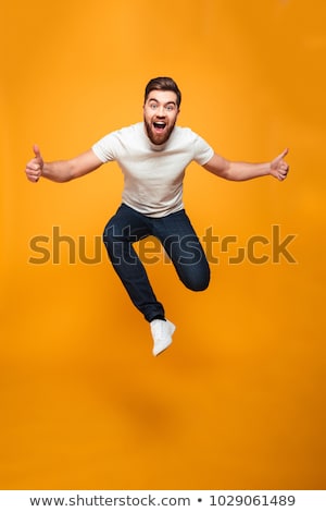 ストックフォト: Full Length Portrait Of A Smiling Young Casual Man Jumping