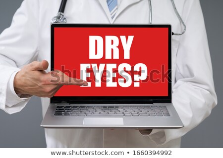 Stok fotoğraf: Doctor Holding Laptop With The Text Dry Eyes