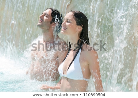 Stockfoto: Woman In Swimming Pool Under The Waterfall