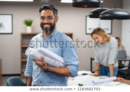 Stock foto: Casual Architect Smiling At Camera Holding Blueprints