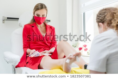 Foto stock: Woman Choosing Nail Polish In Beauty Parlor