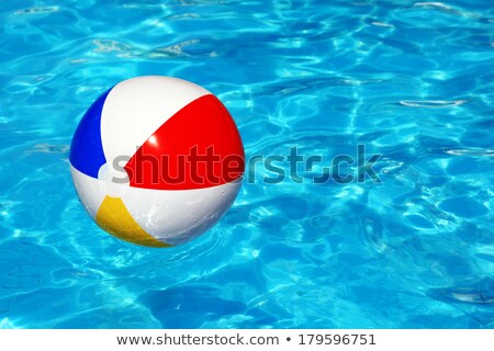 [[stock_photo]]: Red White Beach Ball Floating In Swimming Pool