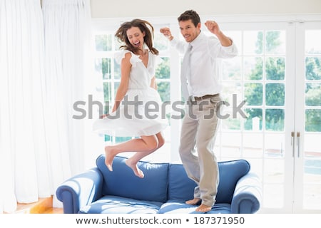 Stockfoto: Excited Couple Jumping Together In Mid Air