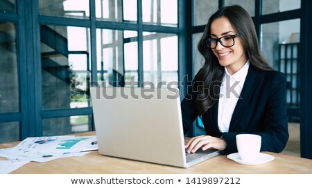 Foto d'archivio: Portrait Of A Young Attractive Businesswoman In A Suit Typing