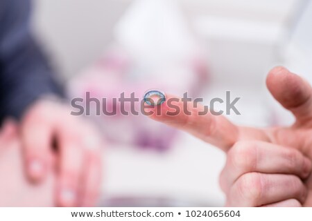 Stok fotoğraf: Saleswoman In Optician Shop Showing Contact Lens