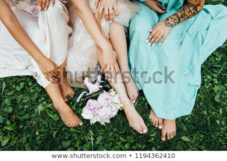 Foto stock: Feet Of The Bride And Her Bridesmaids On The Green Grass In Summer Time