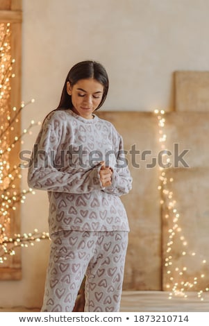 Stock fotó: Cute Young Woman In Pajamas Standing With Christmas Present Boxes And Having Fun On Blue Background