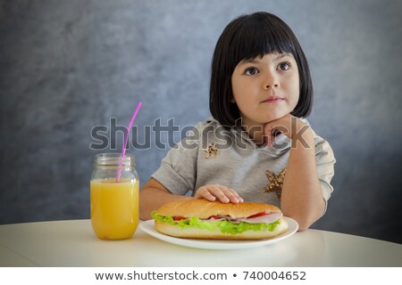 Stok fotoğraf: Cute Black Hair Little Girl Having Breakfast And Drinking Orange