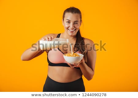 Foto d'archivio: Image Of European Chubby Woman In Tracksuit Holding Milk And Cor