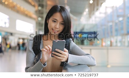 Stok fotoğraf: Young Woman Using A Public Phone In An Airport