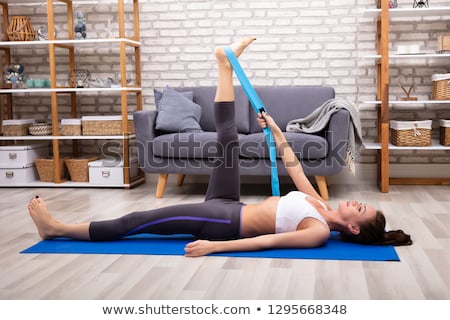 Stockfoto: Woman Using Yoga Belt While Doing Exercise