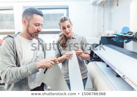 Foto stock: Man And Woman Discussing A Large Format Print
