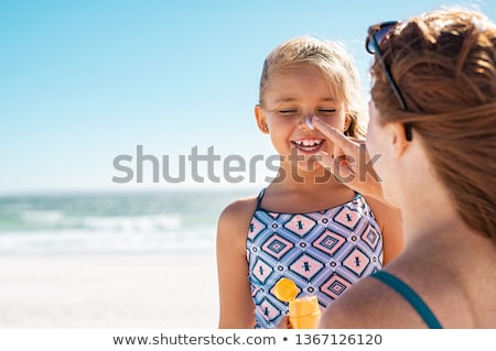 Stockfoto: Putting On Sunscreen