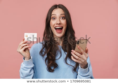 Stock foto: Photo Of Delighted Charming Girl Holding Cellphone And Credit Card