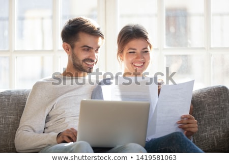 Stok fotoğraf: Young Man Looking At Paper Laughing