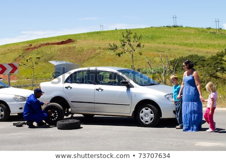 [[stock_photo]]: Woman Tyre Change Car Break Down Remote Street
