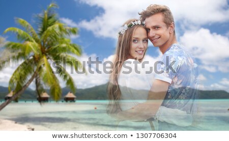 Сток-фото: Hippie Couple Fading Over Exotic Beach Background