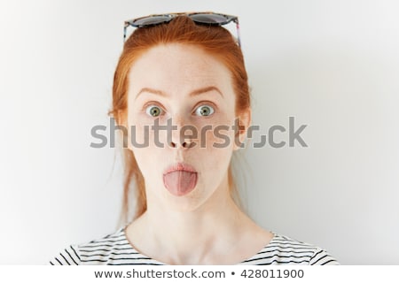 Foto stock: Smiling Red Haired Teenage Girl Showing Her Tongue