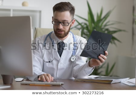Stockfoto: Doctor Looking At Xray Of Elbow