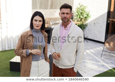 Stock photo: Portrait Of Confident Young Man Holding Champagne Flute While Fr