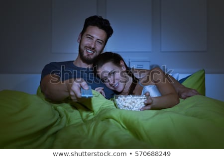 ストックフォト: Happy Couple Watching Tv In Bed At Night At Home