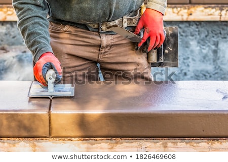 Stockfoto: Construction Worker Using Hand Groover On Wet Cement Forming Cop