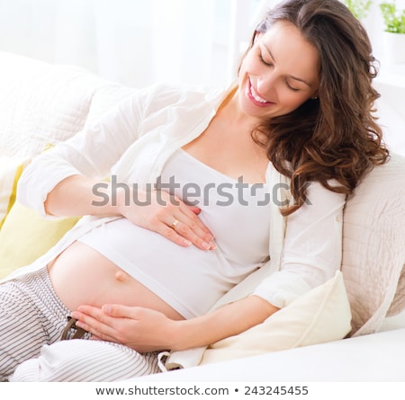 Stock photo: Happy Pregnancy Woman Sitting On Sofa At Her Home