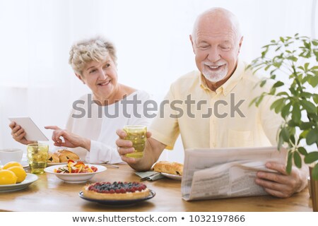 Stok fotoğraf: Couple Reading Newspaper During Breakfast