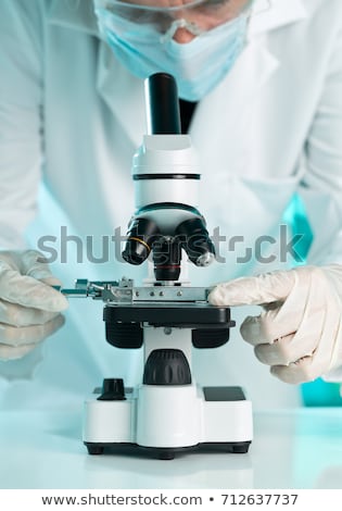 Foto stock: Doctor Hands With Microscope Over Blue Background