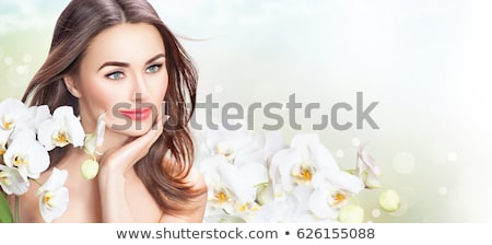 Foto stock: Etrato · de · uma · mulher · bonita · com · uma · orquídea · no · cabelo