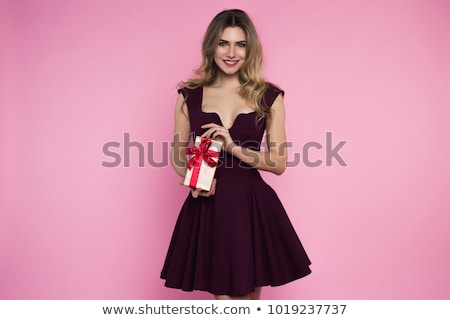 Stok fotoğraf: Charming Pretty Girl Is Holding A Tiny Box With A Present In Hand White Brick Background