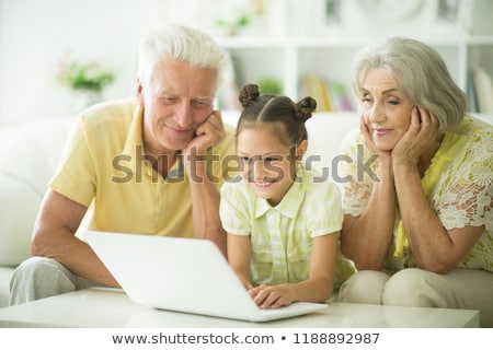 Foto stock: Retired Senior Woman Sitting At Home Using Her Laptop