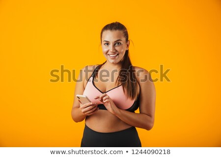 Stock foto: Portrait Of Healthy Chubby Woman In Sportive Bra Using Mobile Ph