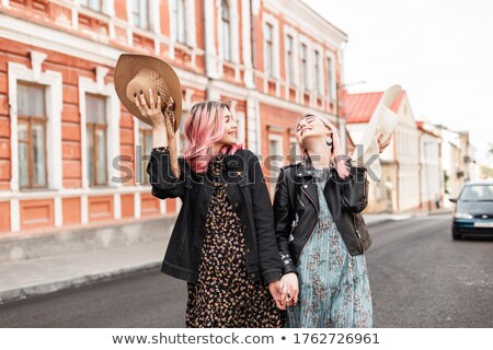 Tredny Smiling Girlfriends Walking Along The Street With The Only Man Stok fotoğraf © Alones